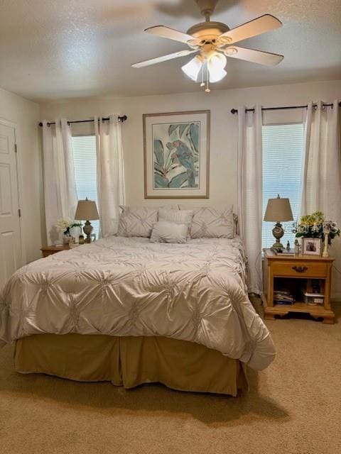 bedroom featuring carpet flooring, a textured ceiling, and ceiling fan