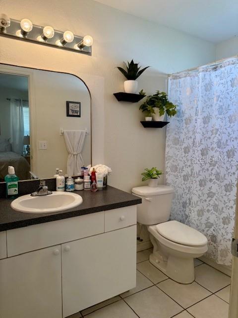 bathroom with tile patterned flooring, toilet, and vanity