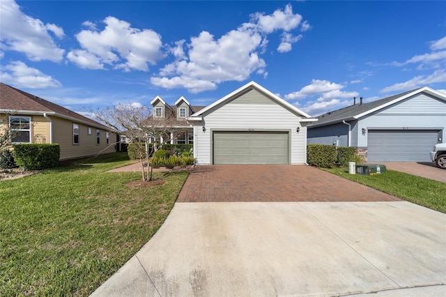 view of front of property featuring an attached garage, a front lawn, and decorative driveway