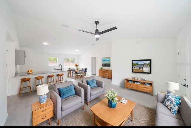 living area featuring a ceiling fan, light wood-style floors, and lofted ceiling