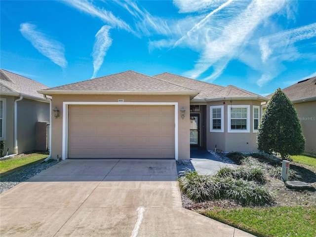 ranch-style house with an attached garage, driveway, a shingled roof, and stucco siding