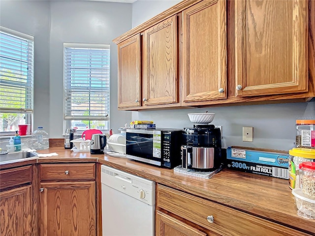 kitchen with butcher block counters, brown cabinetry, and dishwasher