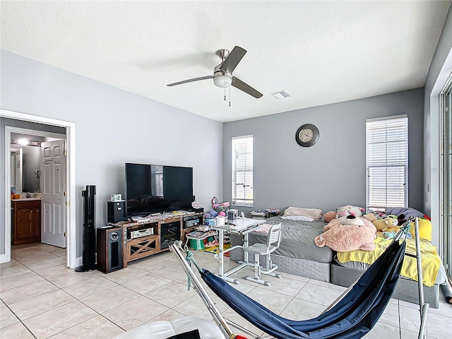 bedroom featuring ceiling fan, visible vents, a textured ceiling, and light tile patterned flooring