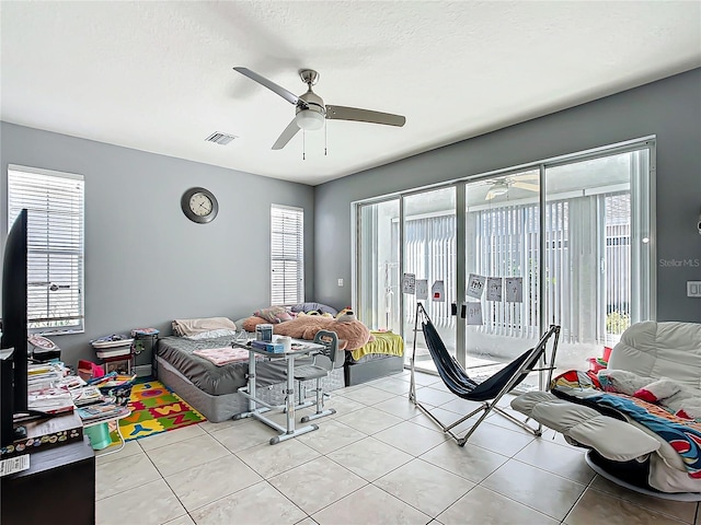 bedroom featuring light tile patterned floors, multiple windows, and access to exterior