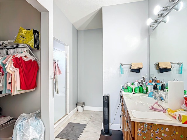 full bath with baseboards, tile patterned flooring, vanity, and a shower stall