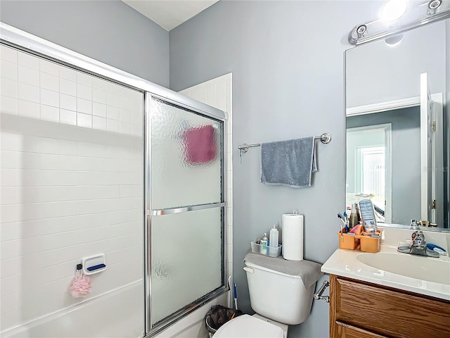 full bathroom featuring combined bath / shower with glass door, vanity, and toilet