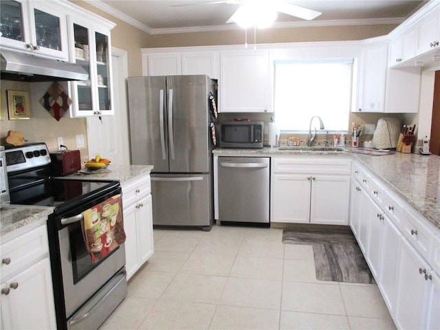 kitchen featuring under cabinet range hood, a sink, white cabinetry, ornamental molding, and appliances with stainless steel finishes