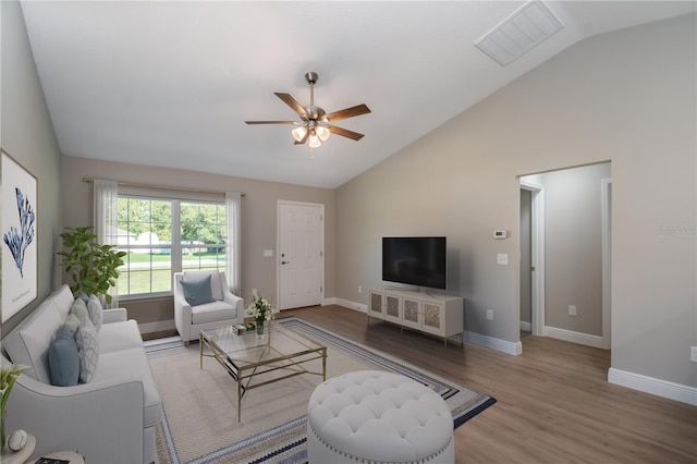 living room featuring lofted ceiling, wood finished floors, visible vents, and baseboards