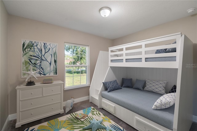 bedroom featuring a textured ceiling, carpet flooring, and baseboards