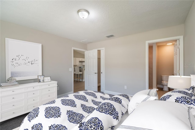 bedroom featuring visible vents, a textured ceiling, and baseboards