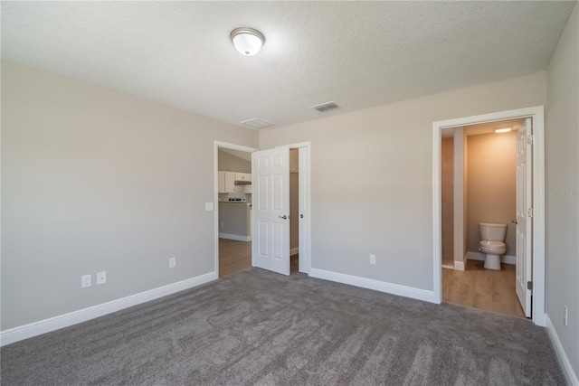 unfurnished bedroom featuring a textured ceiling, visible vents, and baseboards