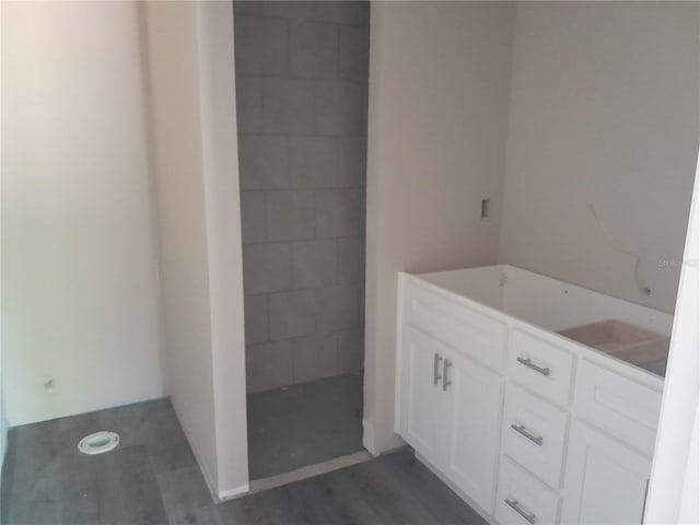 bathroom featuring wood finished floors and tiled shower