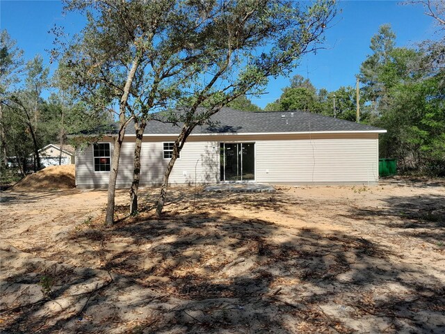 back of property with a shingled roof