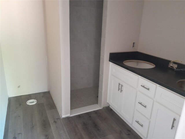 full bathroom with wood finished floors, walk in shower, and double vanity