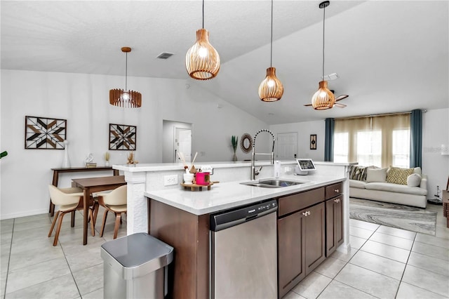 kitchen with a sink, open floor plan, light countertops, light tile patterned floors, and dishwasher