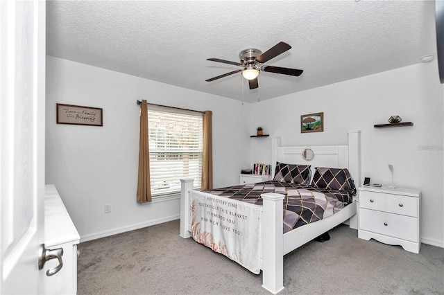 carpeted bedroom with ceiling fan, baseboards, and a textured ceiling