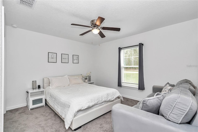 bedroom with visible vents, baseboards, a textured ceiling, and carpet flooring