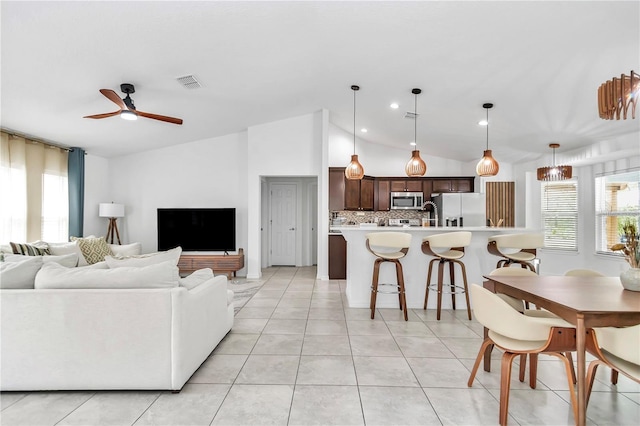 living area with visible vents, a healthy amount of sunlight, lofted ceiling, and ceiling fan