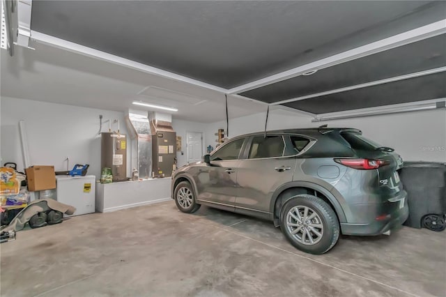 garage featuring heating unit and water heater