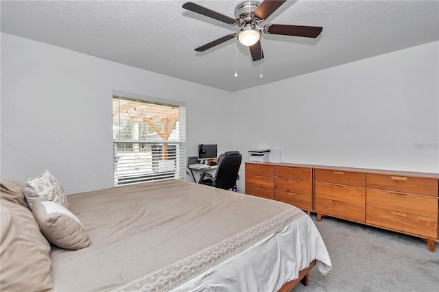 bedroom with a textured ceiling, ceiling fan, and light carpet