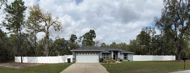 view of front facade featuring driveway, an attached garage, a front lawn, and fence