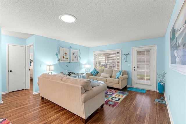 living room featuring a textured ceiling, wood finished floors, and baseboards