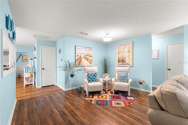 living area with attic access, baseboards, and wood finished floors