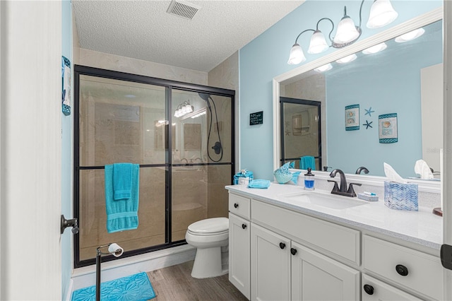 full bathroom with toilet, a textured ceiling, a shower stall, and visible vents