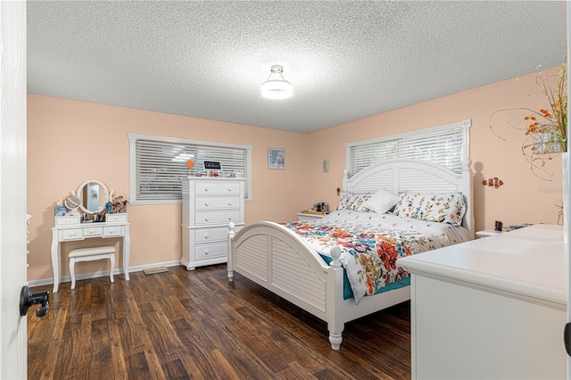 bedroom with dark wood-style floors, a textured ceiling, and baseboards