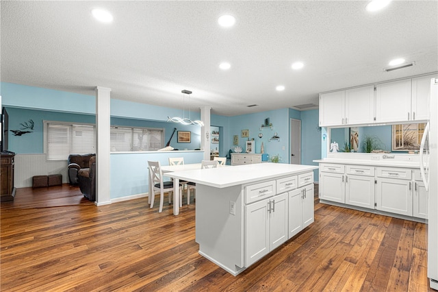 kitchen featuring a textured ceiling, white cabinetry, light countertops, and dark wood-style flooring