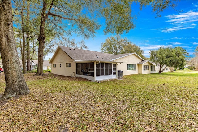 back of property with a sunroom and a yard