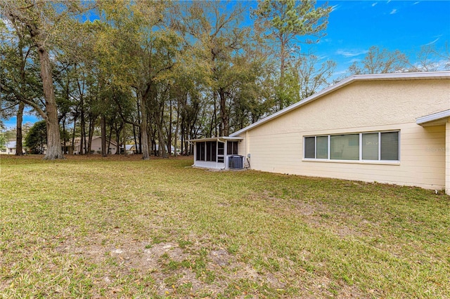 view of yard with a sunroom and central AC