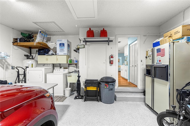 garage featuring white fridge with ice dispenser, washer and dryer, a sink, and concrete block wall