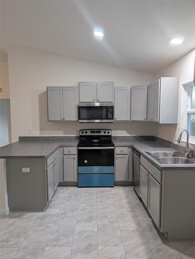 kitchen featuring stainless steel appliances, gray cabinets, a peninsula, and a sink