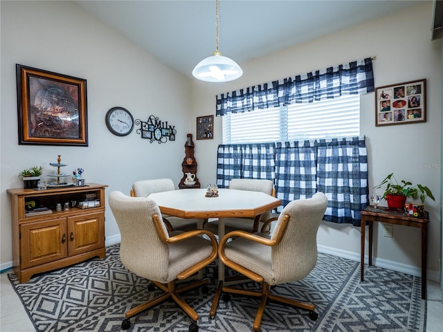 dining room with lofted ceiling and baseboards