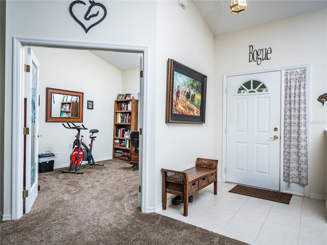 foyer entrance featuring light carpet, baseboards, and light tile patterned floors