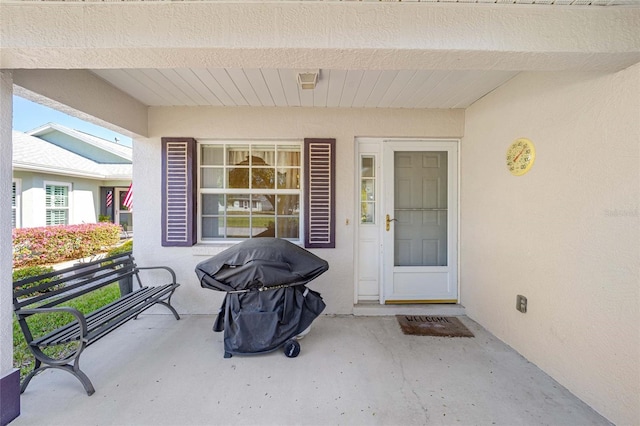 entrance to property featuring stucco siding