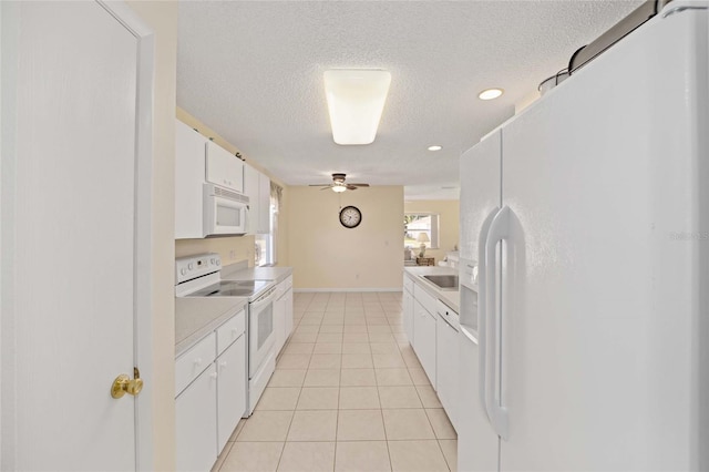 kitchen featuring light tile patterned floors, light countertops, white cabinetry, a textured ceiling, and white appliances