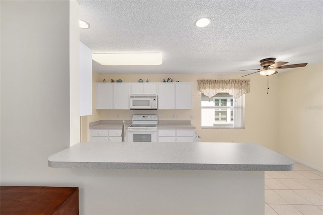 kitchen featuring light tile patterned floors, light countertops, a ceiling fan, white cabinetry, and white appliances