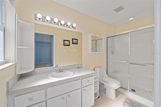 bathroom featuring a stall shower, visible vents, toilet, tile patterned flooring, and vanity