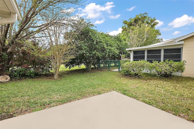 view of yard with a patio area, fence, and a sunroom