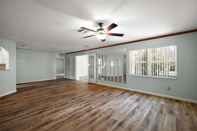 spare room featuring a ceiling fan, a textured ceiling, baseboards, and wood finished floors