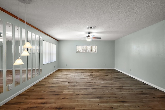 unfurnished room featuring a ceiling fan, visible vents, a textured ceiling, and wood finished floors