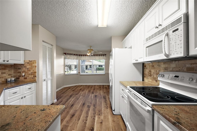 kitchen featuring white appliances, light wood finished floors, baseboards, a ceiling fan, and white cabinetry