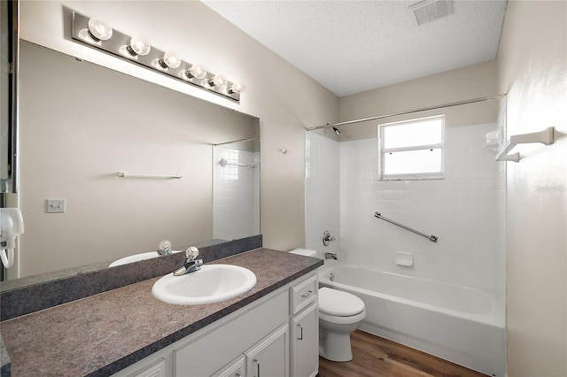 full bath with bathing tub / shower combination, visible vents, toilet, a textured ceiling, and wood finished floors