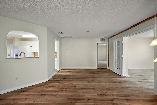 9025 SW 94th Ln Unit C, Ocala, FL 34481 - empty room featuring visible vents, baseboards, wood finished floors, and a textured ceiling