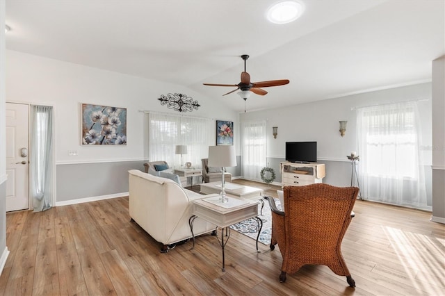 living area featuring lofted ceiling, light wood-style flooring, baseboards, and ceiling fan