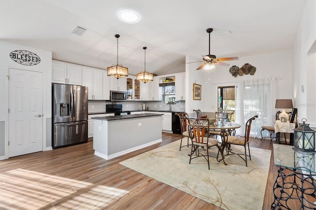 kitchen with visible vents, white cabinets, black appliances, dark countertops, and glass insert cabinets