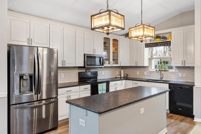 kitchen featuring lofted ceiling, backsplash, glass insert cabinets, a sink, and black appliances