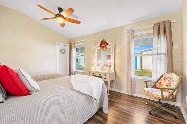 bedroom featuring lofted ceiling, multiple windows, baseboards, and wood finished floors